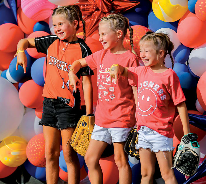 Young fans, Emersyn Edge, Parker Reimer and Emersyn Hensley wait to enter the stadium before the championship series softball game of the Women's College World Series between the University of Oklahoma Sooners (OU) and the Texas Longhorns at USA Softball Hall of Fame Stadium in Oklahoma City, on Wednesday, June 8